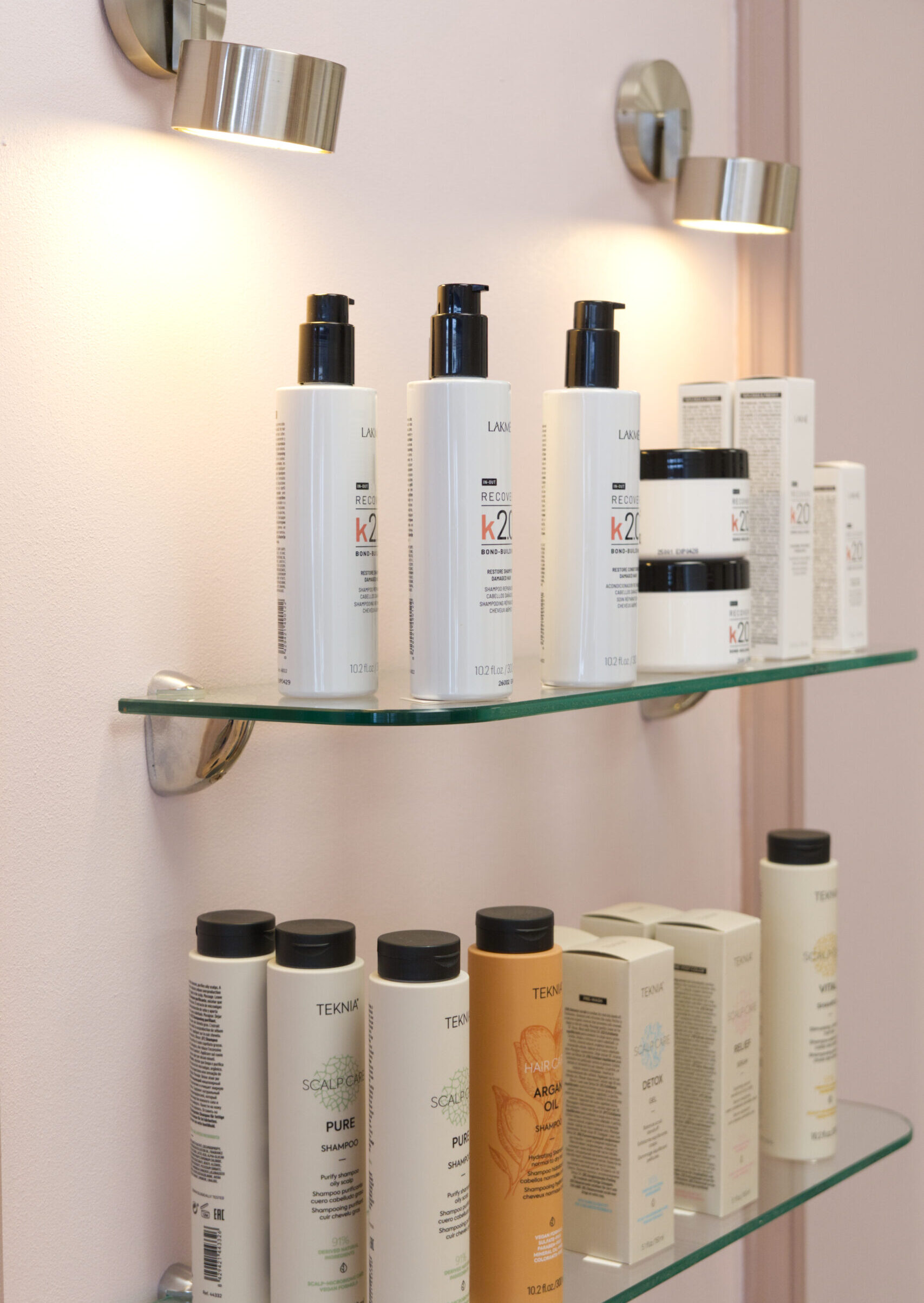 Produits de soins capillaires Lakmé exposés sur les étagères du salon Nuance Coiffure à Cossonay